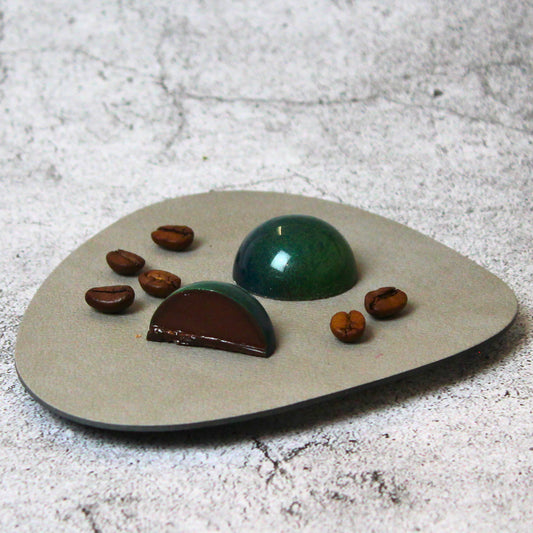 Cremige Kaffee-Kardamom-Praline umhüllt mit dunkler Schokolade.