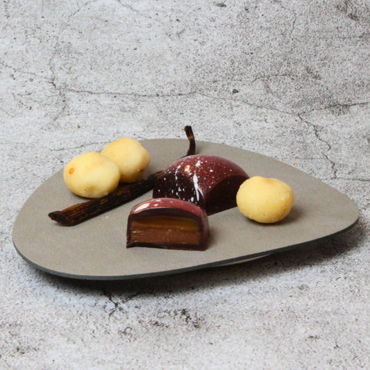 Macadamia-Vanillekaramell-Praline - cremiges Vanillekaramell auf Macadamia-Nougat, umhüllt mit dunkle Schokolade