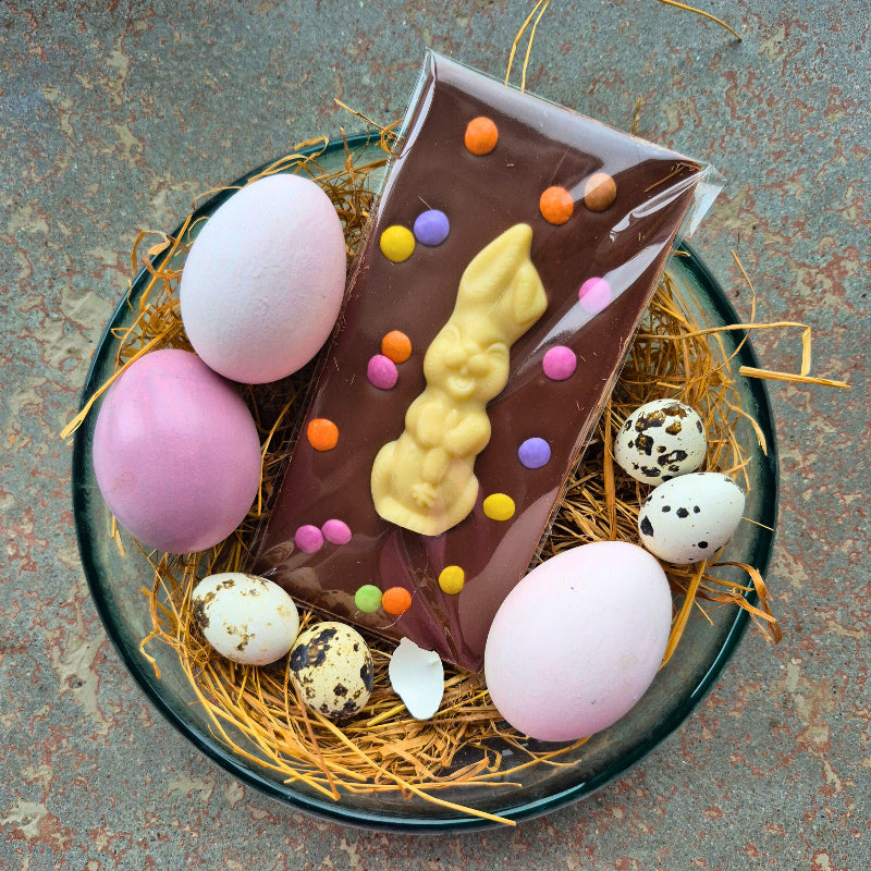 Tafelschokolade mit Vollmilchschokolade, belegt mit einem Osterhasen aus weißer Schokolade, bestreut mit Schoko-Linsen