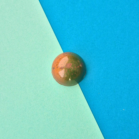 Zweischichtige Praline Café-Caramel mit crunchigem Pistazien-Nougat, in Vollmilchschokolade, bronze-grün
