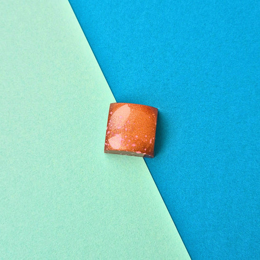 Handgegossene Praline mit cremigen Haselnuss-Gianduja, rose-bronze geschminkt