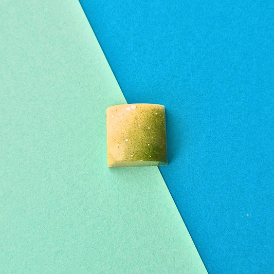 Handgegossene Praline Pistazie-Joghurt in weißer Schokolade, grün und weiß gestaltet