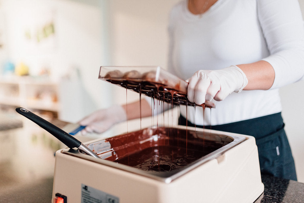 Eine gefüllte Pralinenform wird ausgegossen